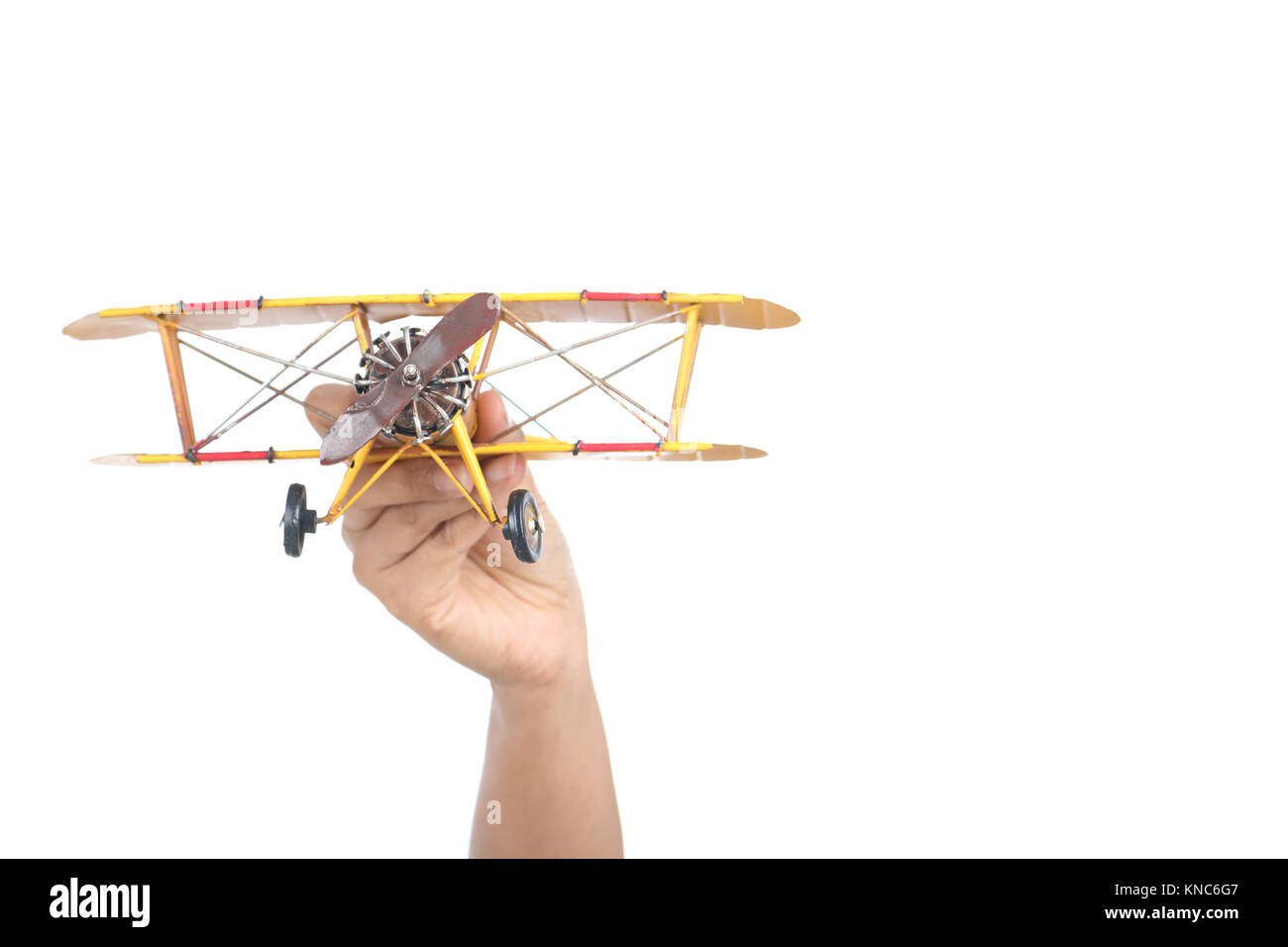 Hand holding toy airplane, isolé sur fond blanc Banque D'Images