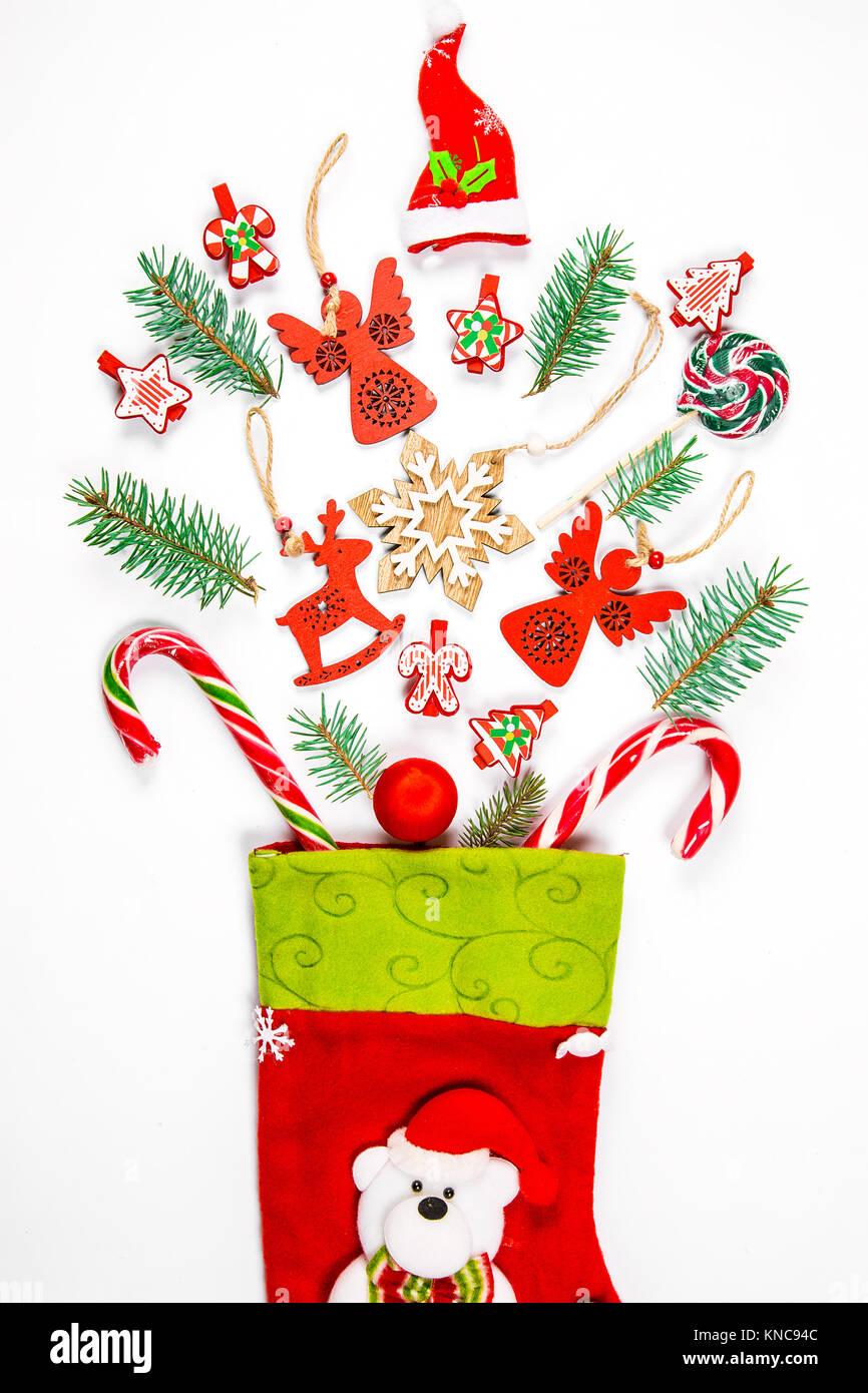 Noël arrière-plan avec une chaussette à partir de laquelle les cadeaux éparpillés, des bonbons, des décorations du Nouvel An jouets sur un fond blanc. Le concept de la publicité, de la shopp Banque D'Images