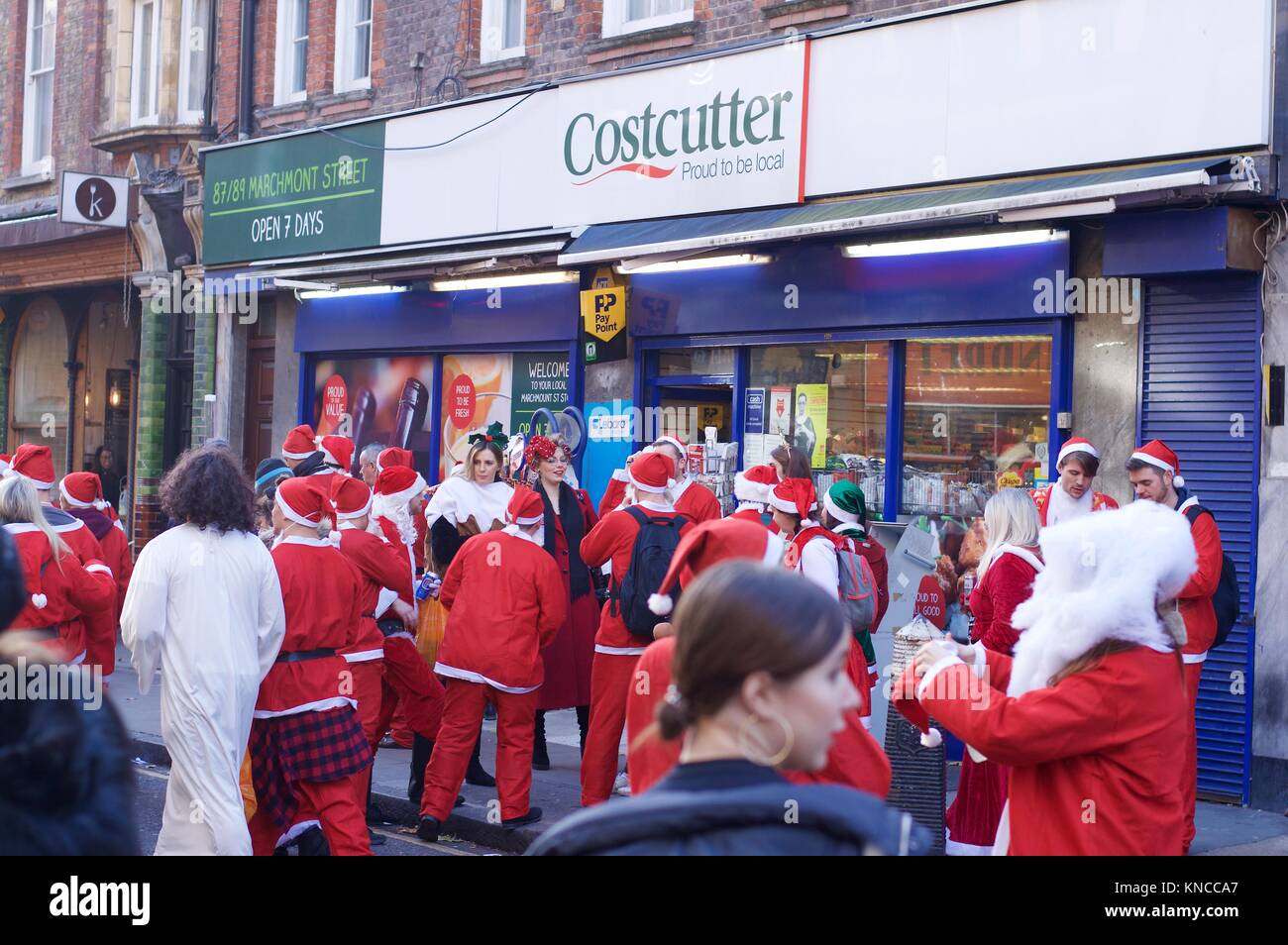 Flash mob habillé en père Noël marche à travers Londres, buvant, et se réjouissant pour Santacon 2017 dans le nord de Londres, King's Cross area Banque D'Images