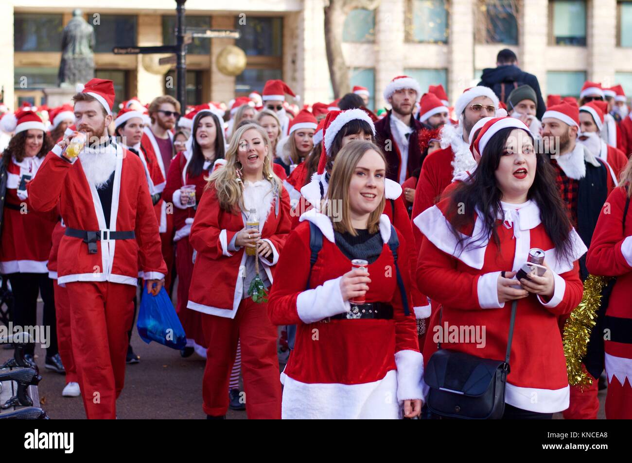 Flash mob habillé en père Noël marche à travers Londres, buvant, et se réjouissant pour Santacon 2017 dans le nord de Londres, King's Cross area Banque D'Images