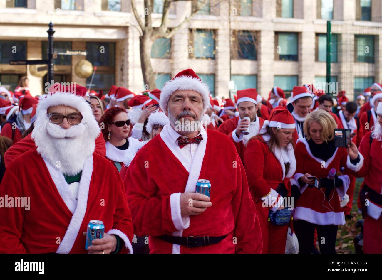 Flash mob habillé en père Noël marche à travers Londres, buvant, et se réjouissant pour Santacon 2017 dans le nord de Londres, King's Cross area Banque D'Images