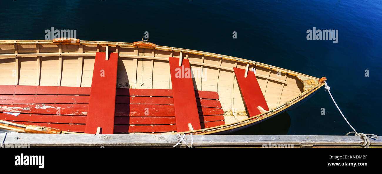 Barque jaune et rouge sur l'eau bleue Banque D'Images