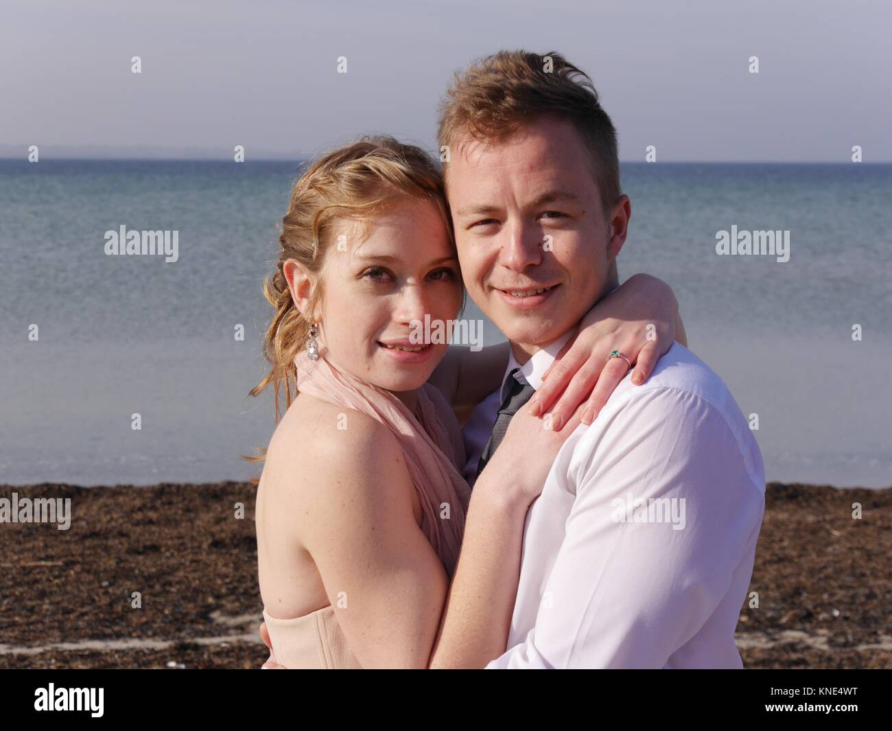 Romantique proche de jeunes couples attrayants amoureux, nouvellement weds, posant sur la plage sur l'île Aero danoise, archipel de South Funen après mariage Banque D'Images