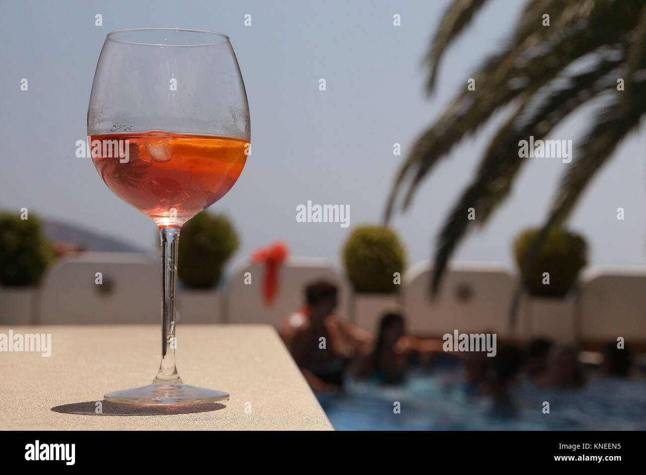 Verre de vin rose par le bord d'une piscine d''un pool party Banque D'Images