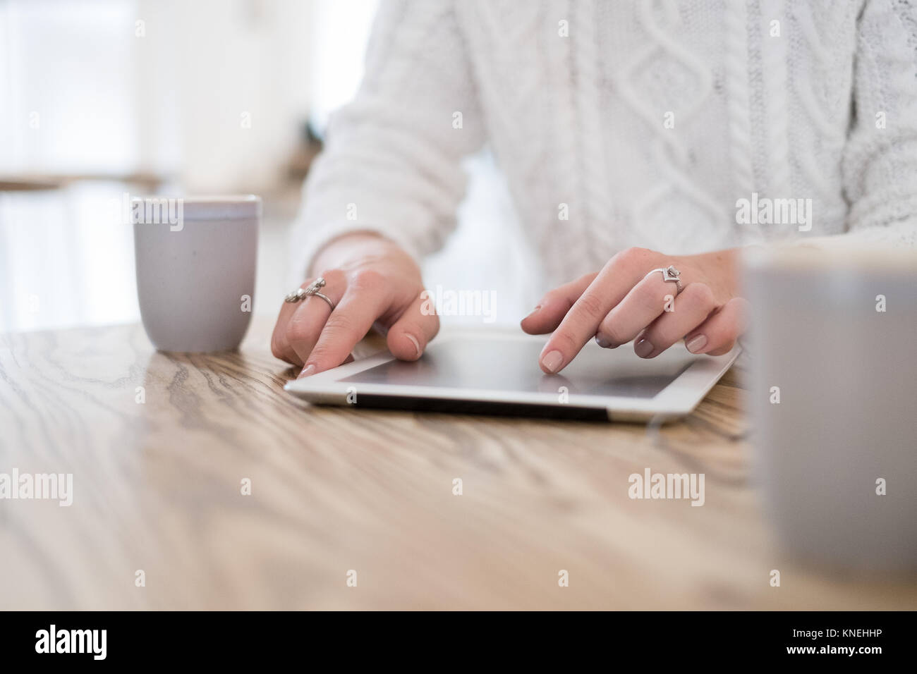 Femme assise à une table à l'aide d'une tablette numérique Banque D'Images