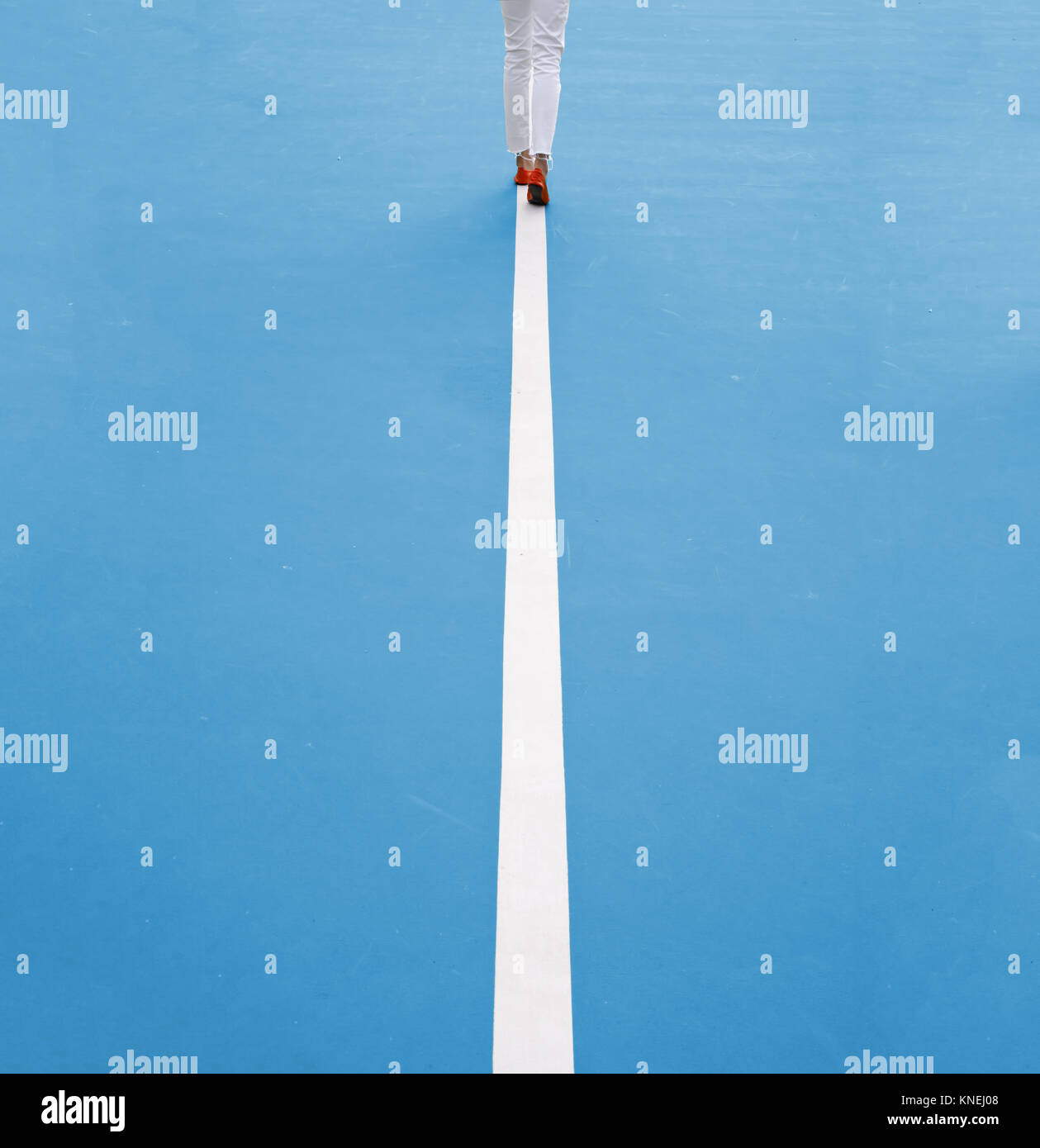 Vue arrière d'une femme marchant le long d'une ligne droite Banque D'Images