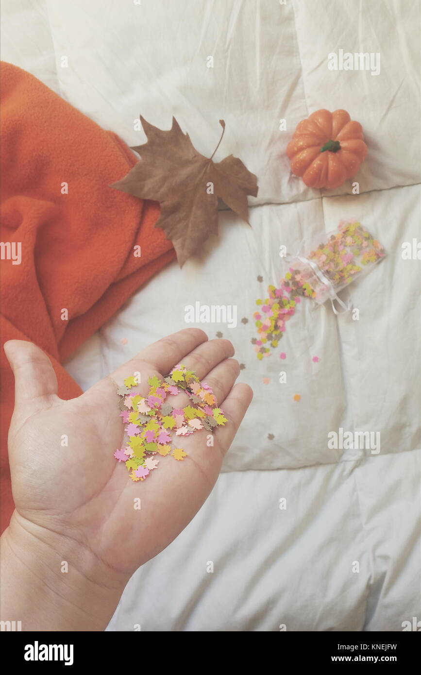 Woman's hand holding confetti et décorations d'automne Banque D'Images