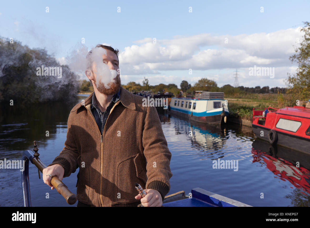 Man smoking e-cigarette sur canal boat Banque D'Images