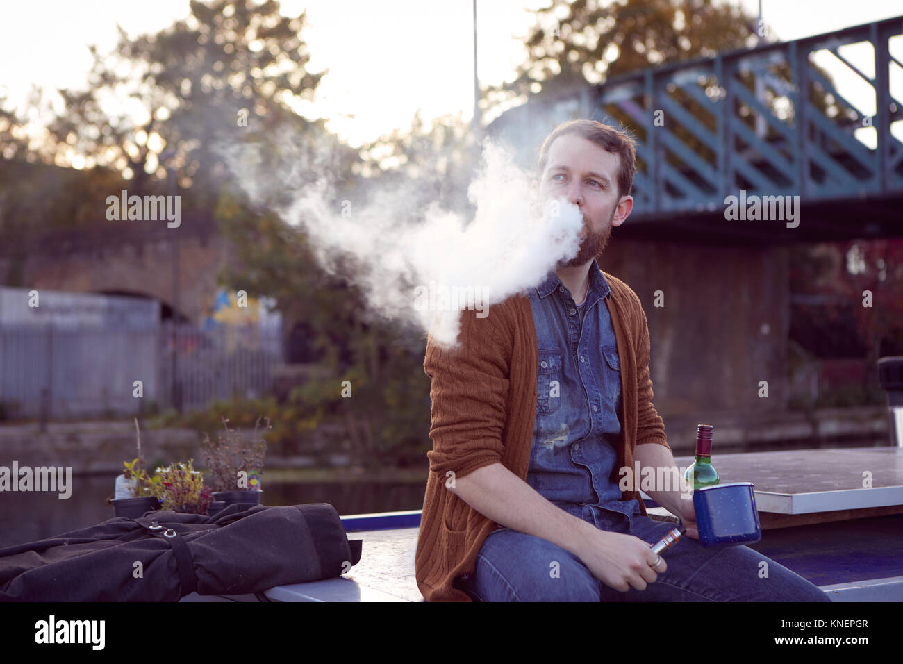 Man smoking e-cigarette sur canal boat Banque D'Images