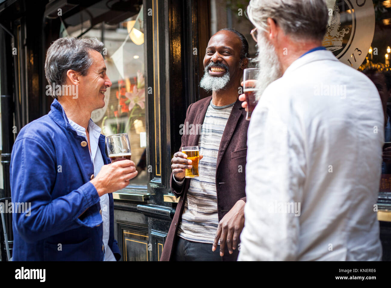 Trois hommes déjà debout à l'extérieur, pub, bière, rire holding Banque D'Images