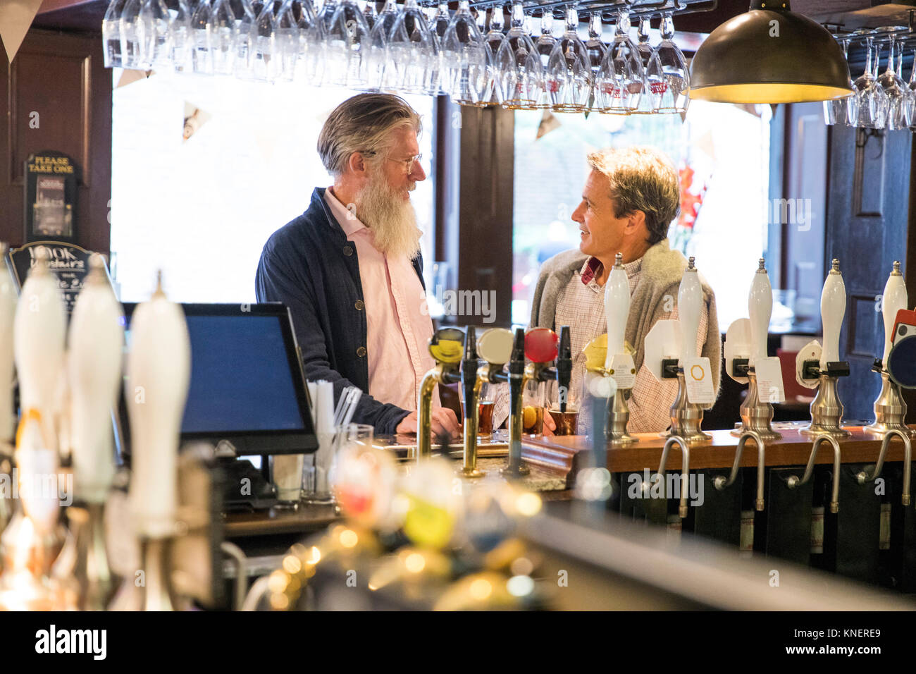 Deux hommes d'âge mûr, assis ensemble dans un pub, parler Banque D'Images