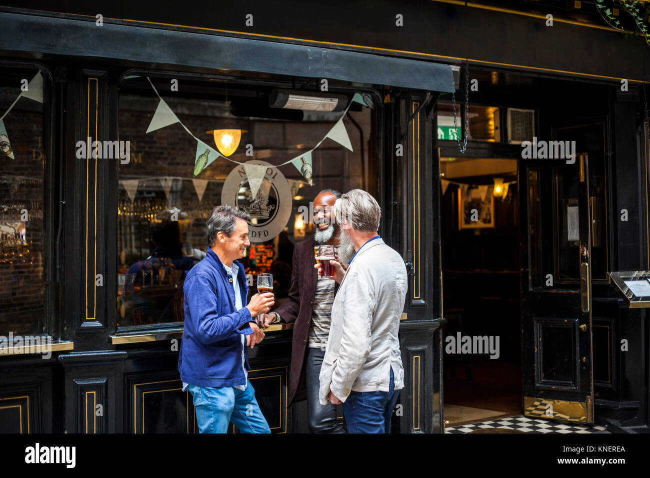 Trois hommes déjà debout à l'extérieur, pub, bière, rire holding Banque D'Images