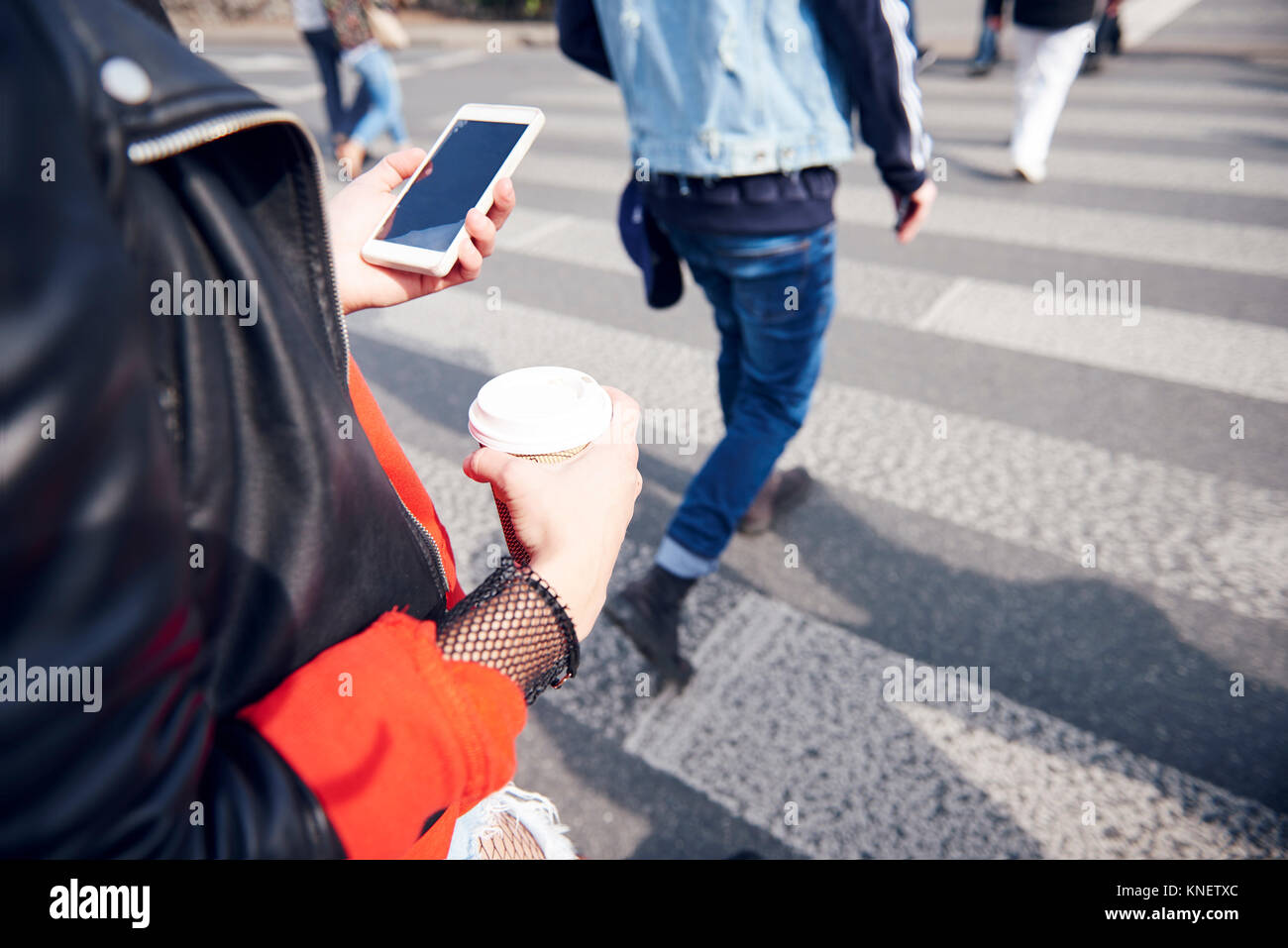 Personne au passage pour piétons avec café et smartphone Banque D'Images