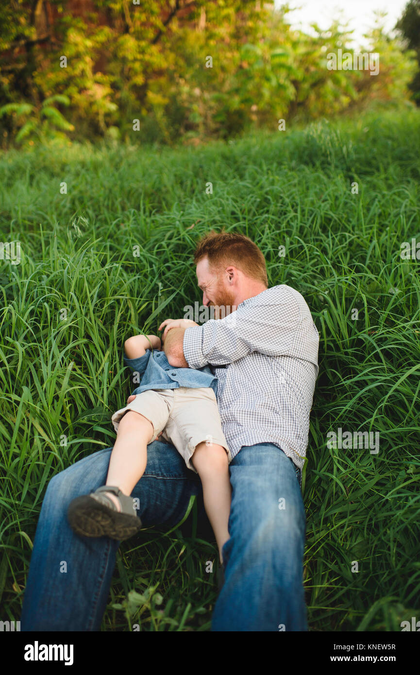 Père Fils de chatouillement dans l'herbe haute Banque D'Images