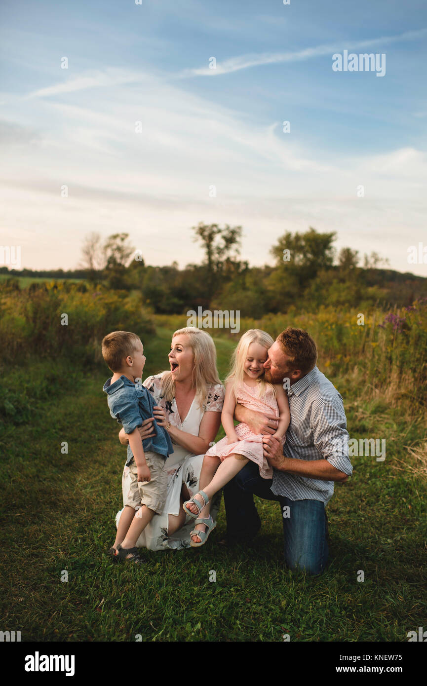 Smiling parents hugging enfants en zone rurale Banque D'Images