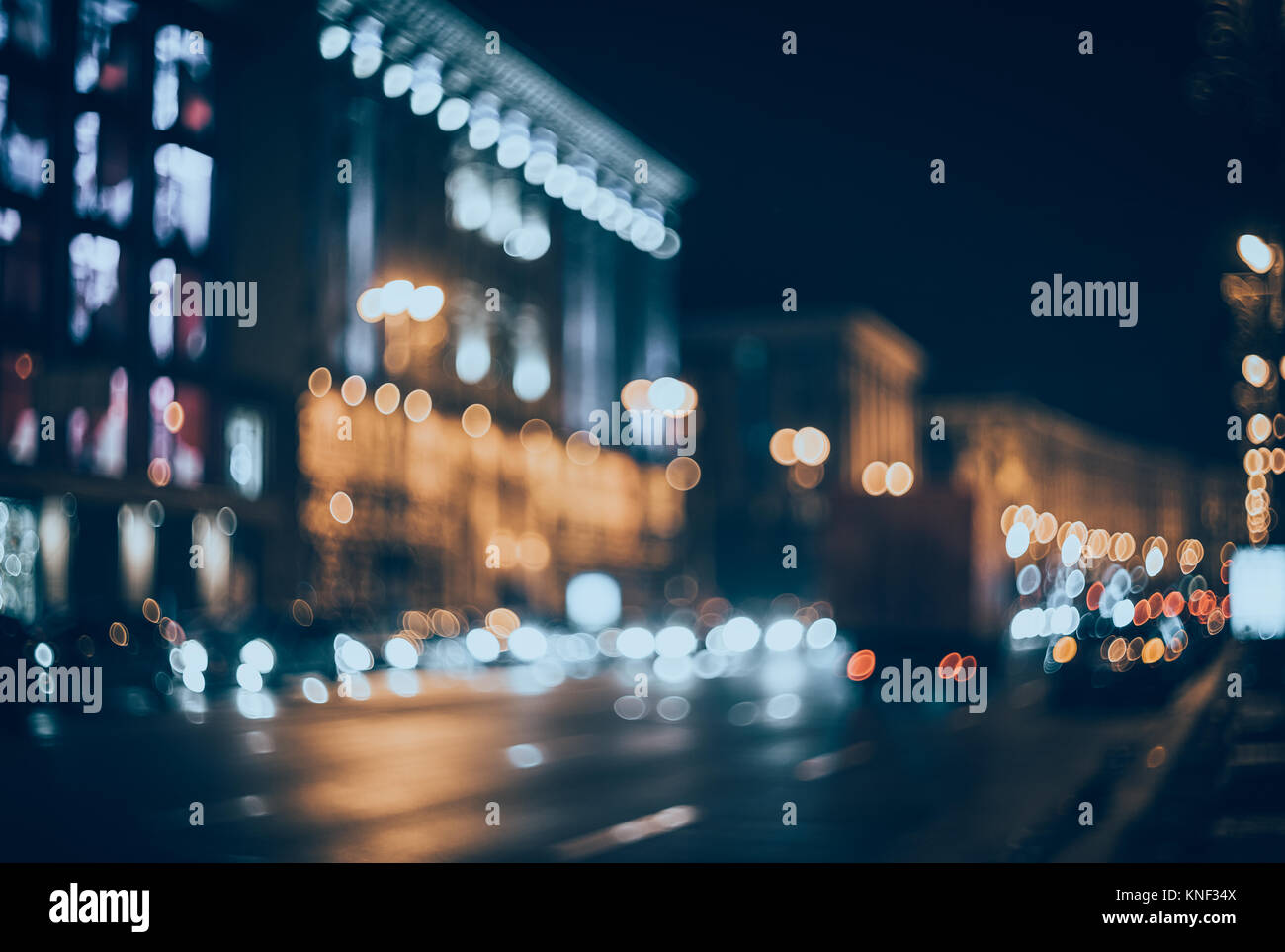 Ville la nuit brouillée. Bokeh. Beau résumé fond flou artistique avec les immeubles, les voitures, les lumières de la ville, les gens. Flou d'arrière-plan avec les couleurs Banque D'Images