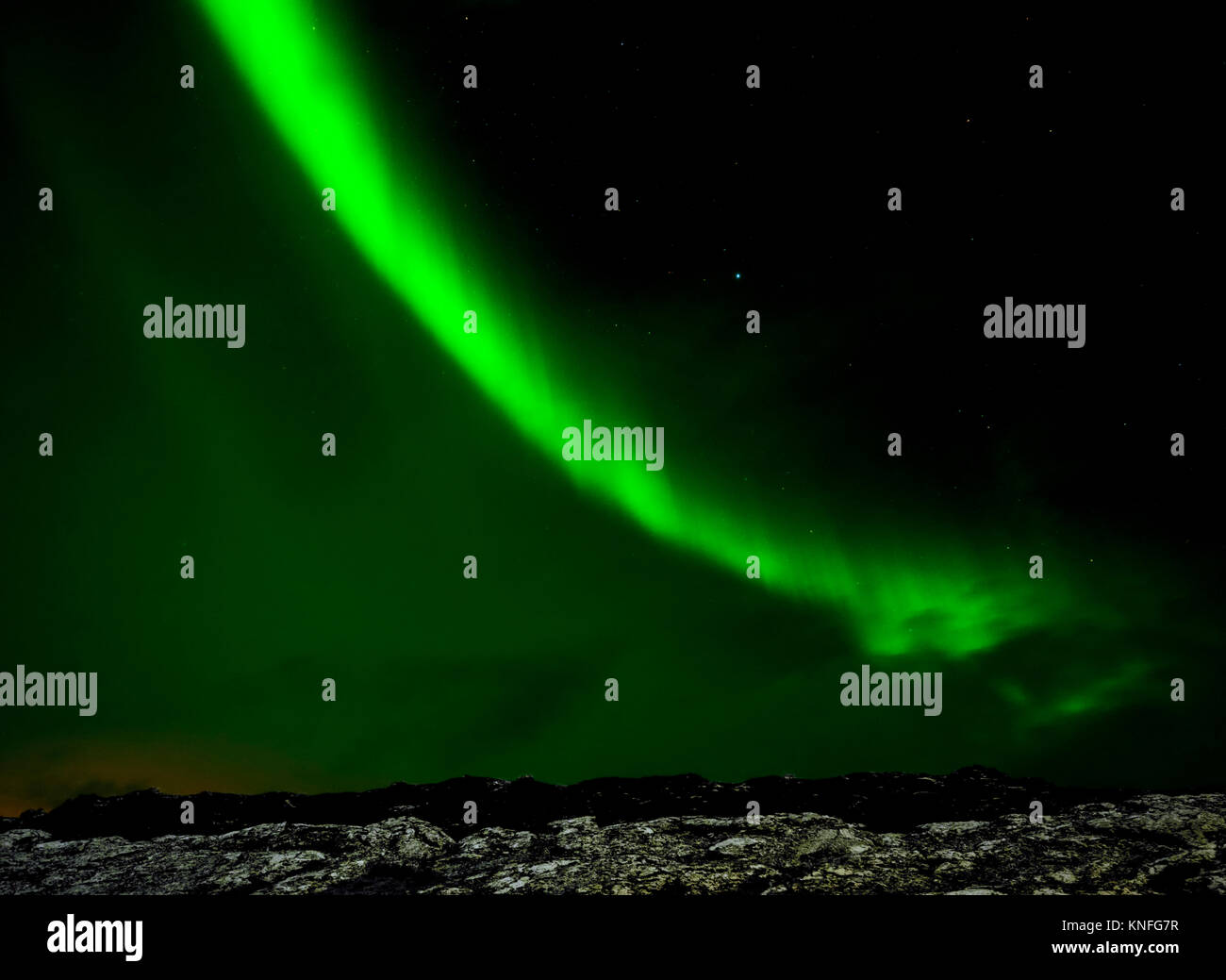 Northern Lights : l'Aurora Borealis contraste avec les roches volcaniques et de la neige dans le Parc National de Thingvellir, 40km au nord-est de Reykjavik, Islande Banque D'Images