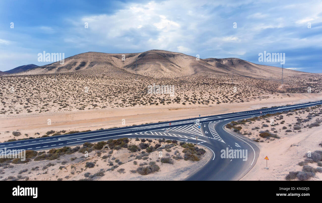 Vue aérienne de route du désert de rejoindre l'autoroute dans les zones arides, montagnes stériles de Fuerteventura, Îles Canaries, Espagne . Banque D'Images