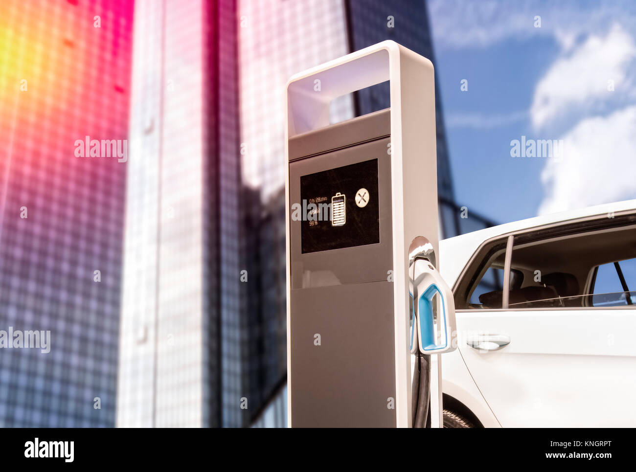 E-voiture à une station de charge en face d'un gratte-ciel Banque D'Images