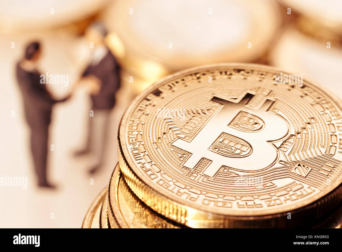 Les hommes d'affaires et des bitcoins en arrière-plan se serrer la main. Banque D'Images