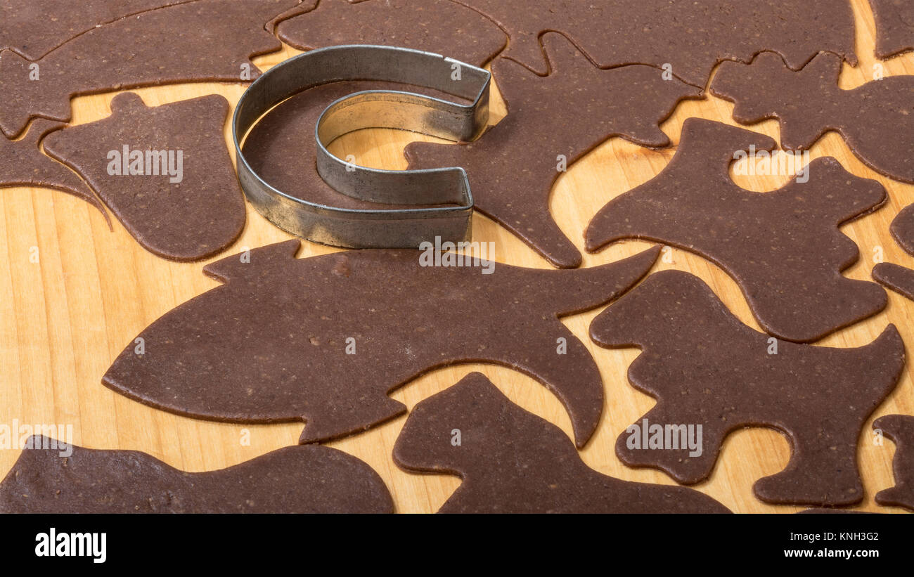 Close-up de découper des pains de Noël sur la table à pétrir. Cutter métallique en forme de fer à cheval, différentes formes de cookies de la pâte roulée. Banque D'Images