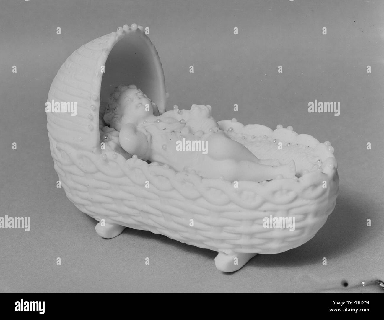 La figure d'un bébé dans un berceau tenant un chaton atteint 140906 284 American, Figure d'un bébé dans un berceau tenant un chaton, 1830 ?70 Parian, porcelaine, 4 3/8 x 6 1/2 x 3 1/8 in. (11,1 x 16,5 x 7,9 cm). Le Metropolitan Museum of Art, New York. Don du Dr. Charles W. Green, 1947 (47.90.159) Banque D'Images