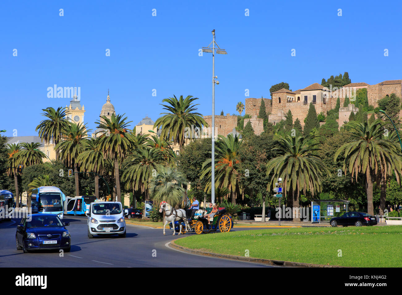 Un cheval transport de touristes équitation passé l'Alcazaba médiévale, l'hôtel de ville et la cathédrale de Malaga sur la Costa del Sol en Espagne Banque D'Images
