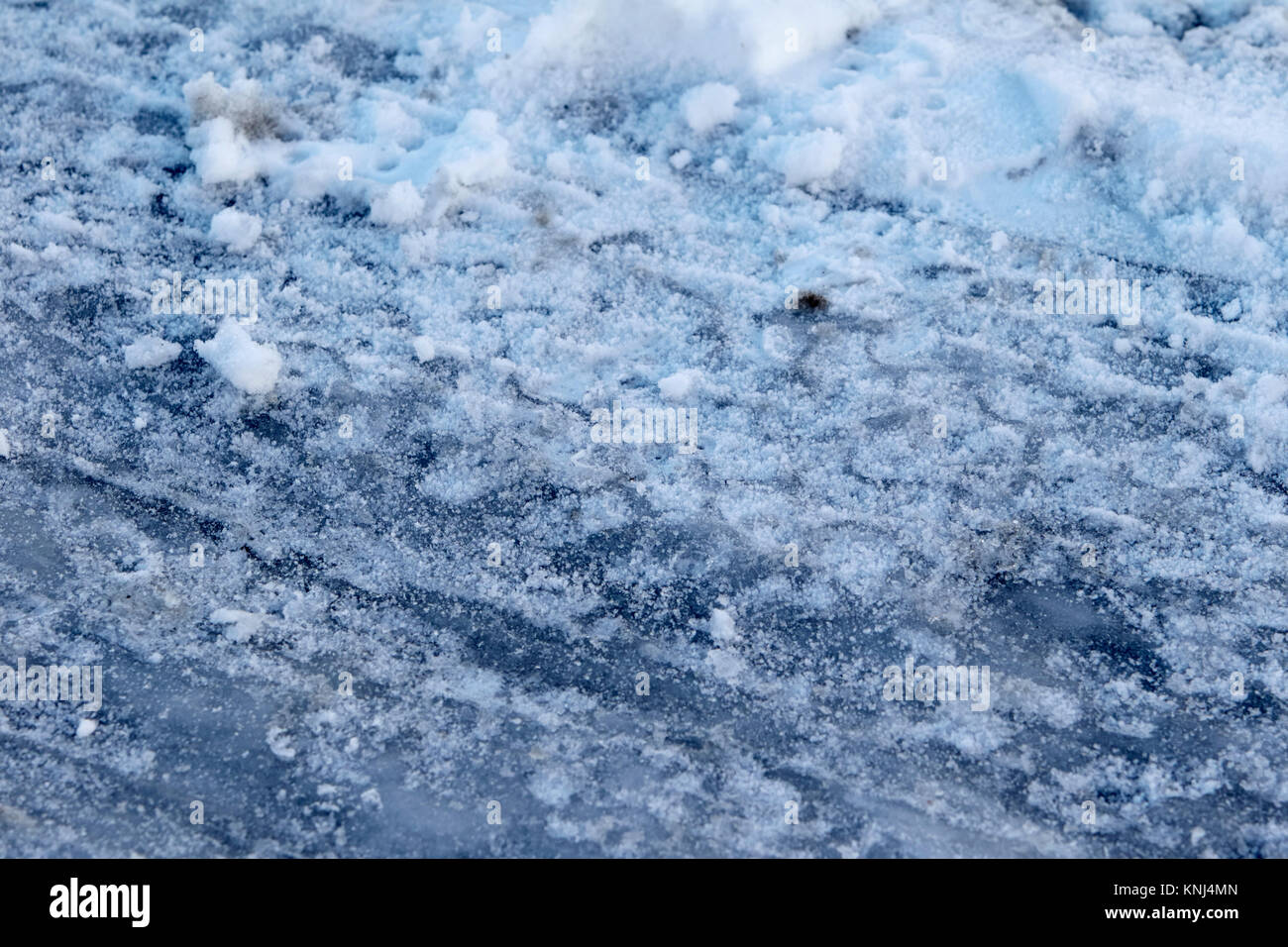 Les traces de pneus dans la neige tassée montrant la glace noire sous la garde d'Irlande Royaume-Uni Banque D'Images