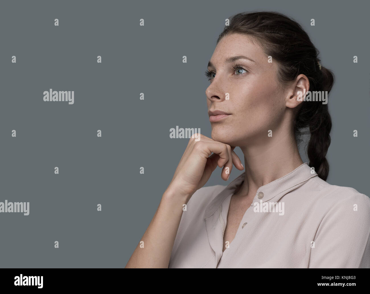 Woman thinking with hand on chin, elle est la planification et la prise de décisions Banque D'Images Woman thinking with hand on chin, elle est la planification et la prise de décisions Banque D'Images