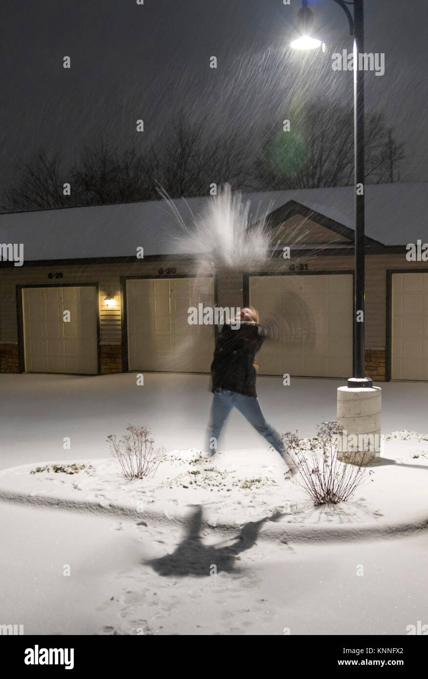 Première neige : une jeune fille de 11 ans au jeu sous l'éclairage comme tempête, Ames, Iowa, USA. Banque D'Images