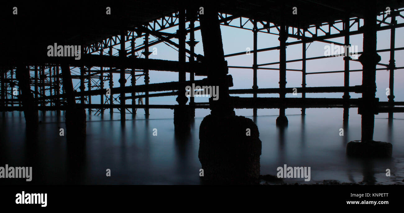 Silhouette d'une longue exposition à la lumière sous Hastings Pier. Banque D'Images