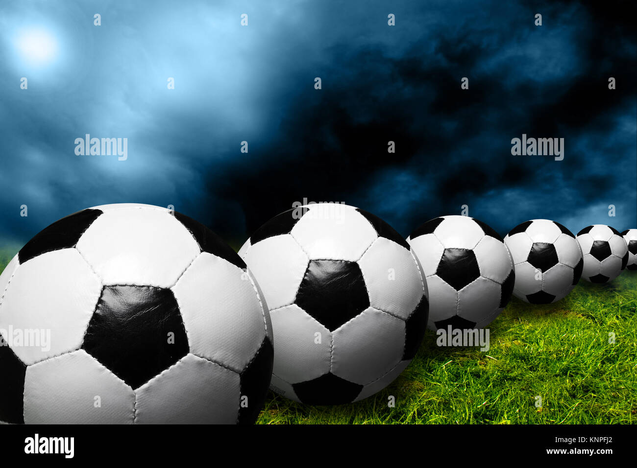Rangée de ballons de soccer avec ciel dramatique Banque D'Images