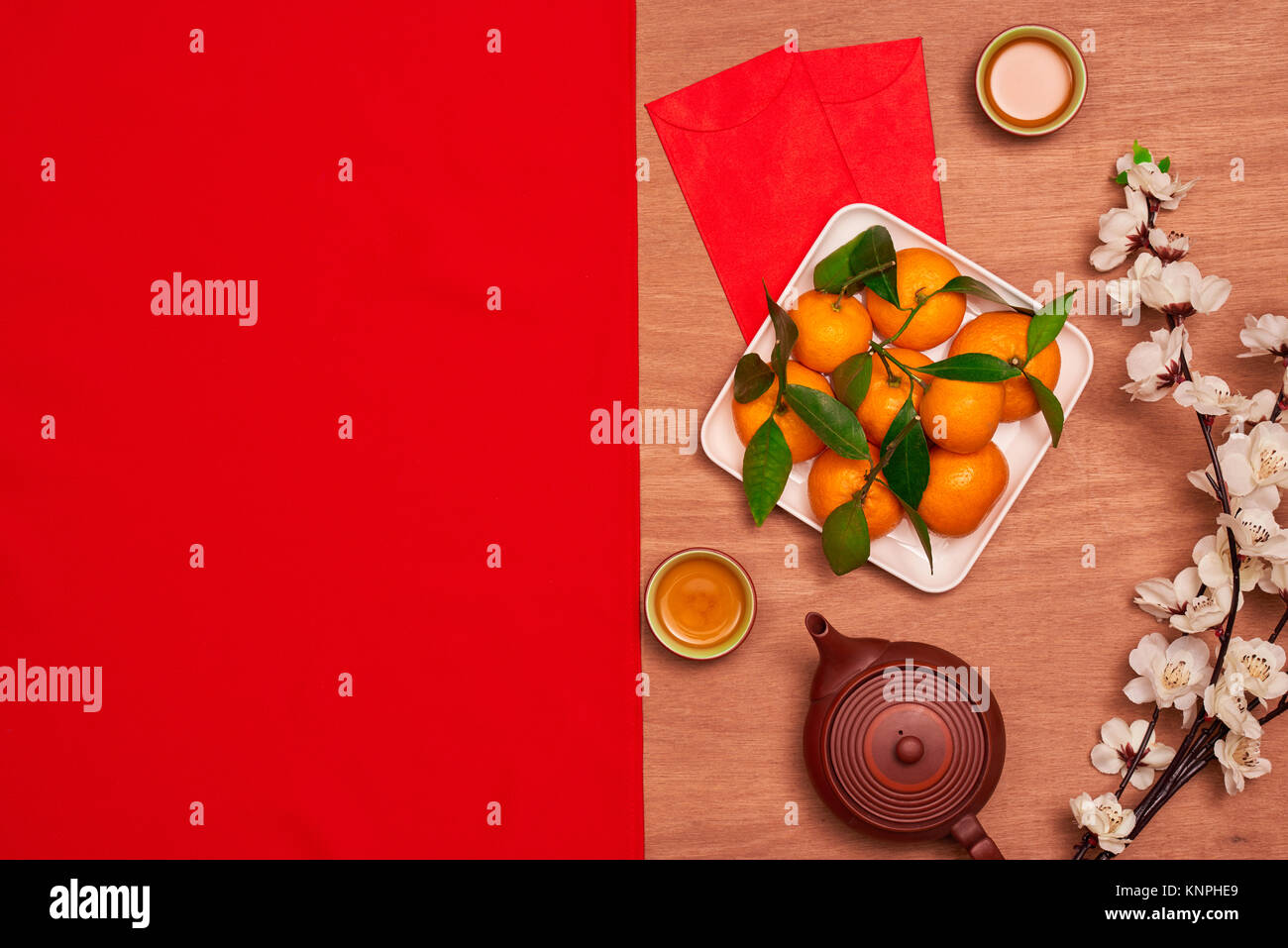 Haut afficher les accessoires le festival du Nouvel an chinois.décorations,orange,feuilles,panier Bois de prunier,paquet rouge sur fond rouge. Banque D'Images