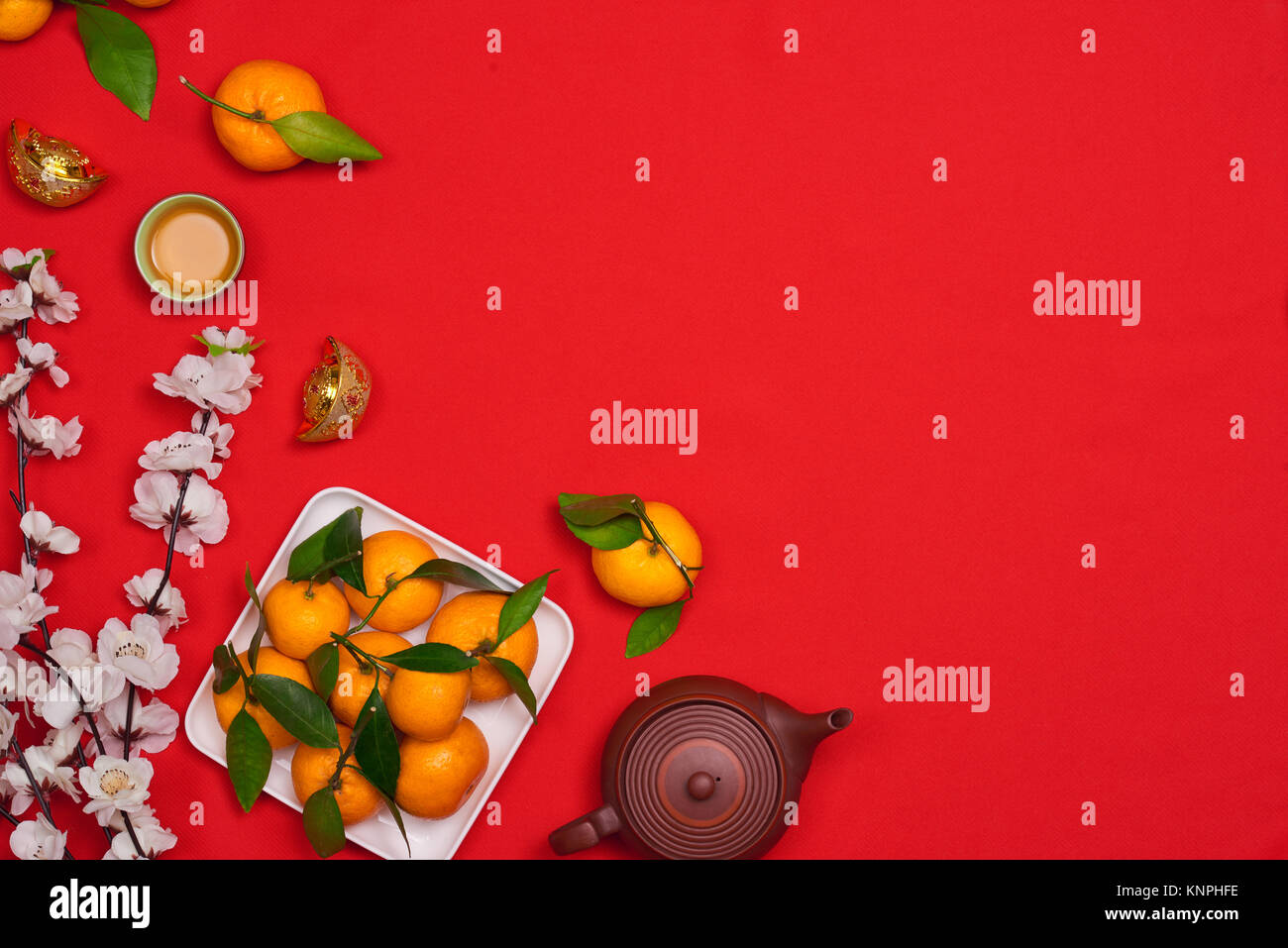 Haut afficher les accessoires le festival du Nouvel an chinois.décorations,orange,feuilles,panier Bois de prunier,paquet rouge sur fond rouge. Banque D'Images