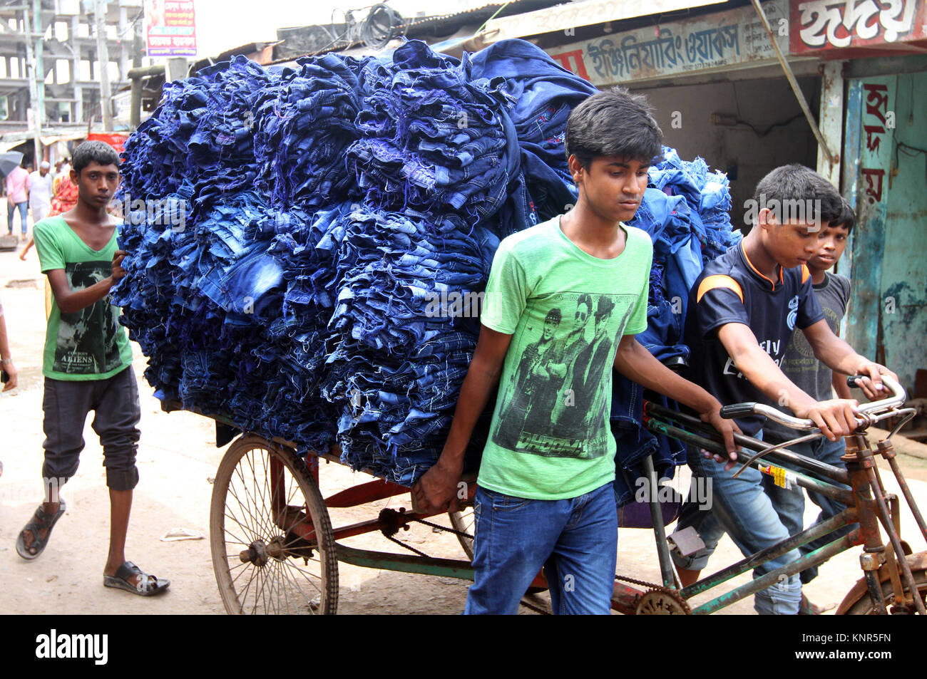 DHAKA, BANGLADESH - 19 juillet 2014 : travailleur du Bangladesh porte pantalons sur un pousse-pousse van au vêtement village de Keraniganj, Dhaka, Bangladesh. Fac Banque D'Images