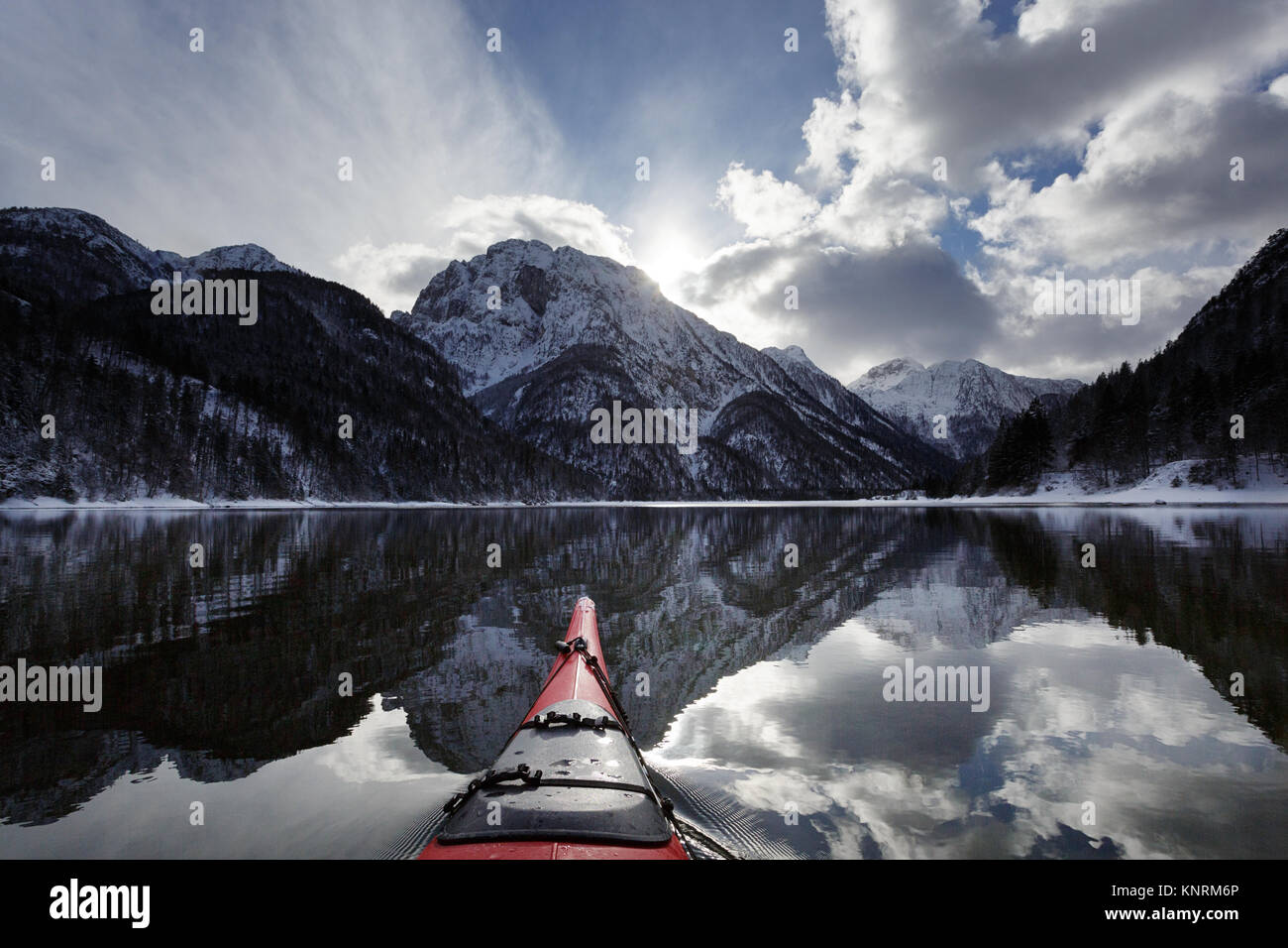 Pointe du kayak rouge dans des conditions hivernales sur une froide journée d'hiver au lac de Predil, Alpes, Italie. Banque D'Images