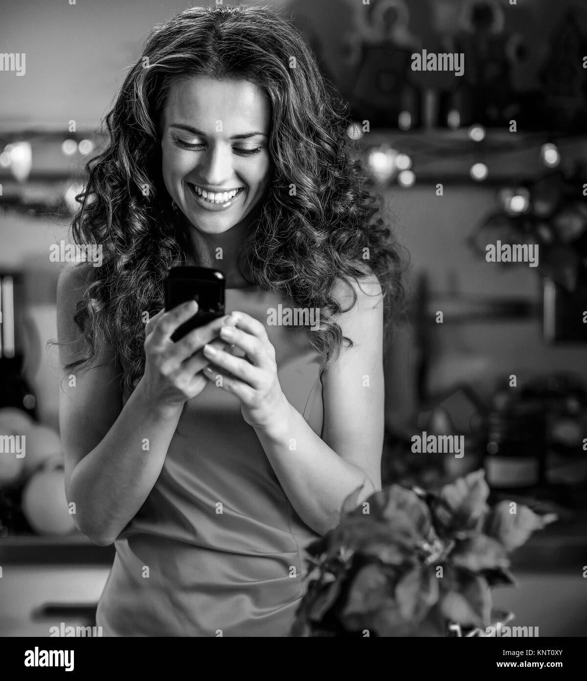 Jeune femme au foyer l'écriture sms en cuisine Décoration de Noël Banque D'Images