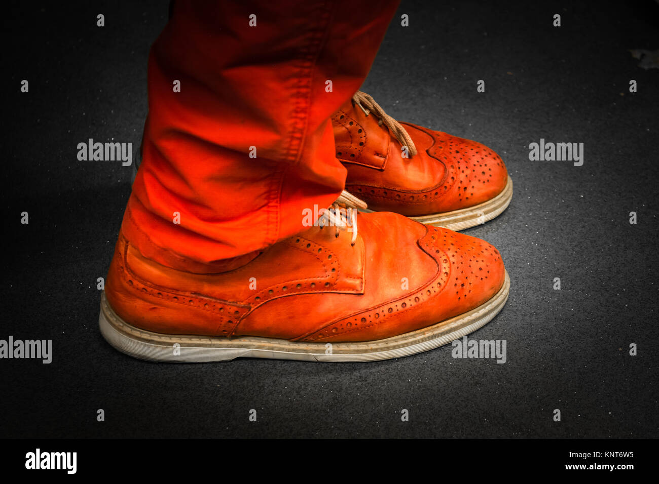 Chaussures en cuir rouge vif correspondant Unique Couleur Pantalon Spotlight isolées portant des chaussures de ville plancher paire ensemble Banque D'Images