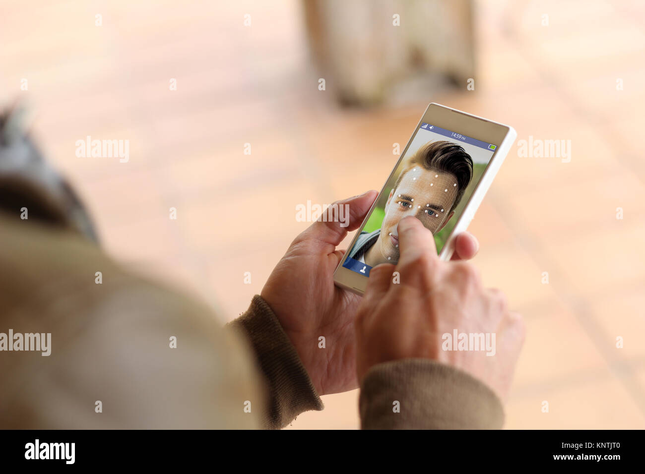 L'homme touchant l'écran de son smartphone pour la reconnaissance faciale. Banque D'Images