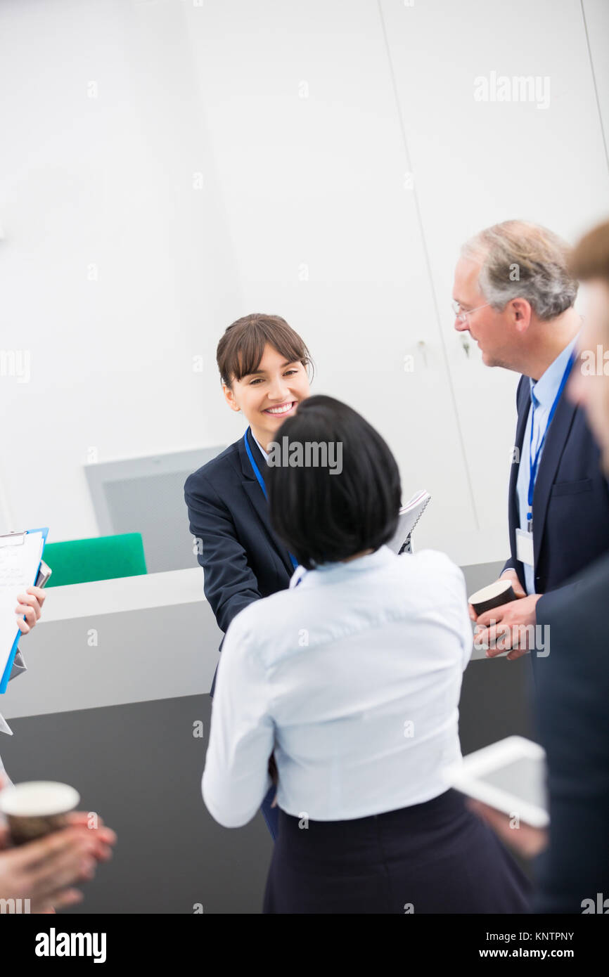 High angle view of smiling businesswoman shaking hands with female colleague in lecture hall Banque D'Images