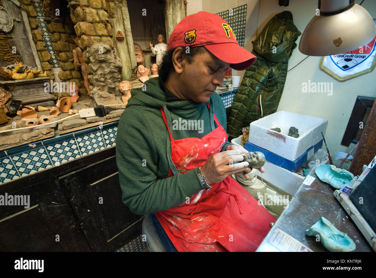 Une statue en terre cuite artisan travaillant dans le célèbre atelier de Giuseppe et Marco Ferrigno, Via San Gregorio Armeno, Naples, Campanie, Italie Banque D'Images