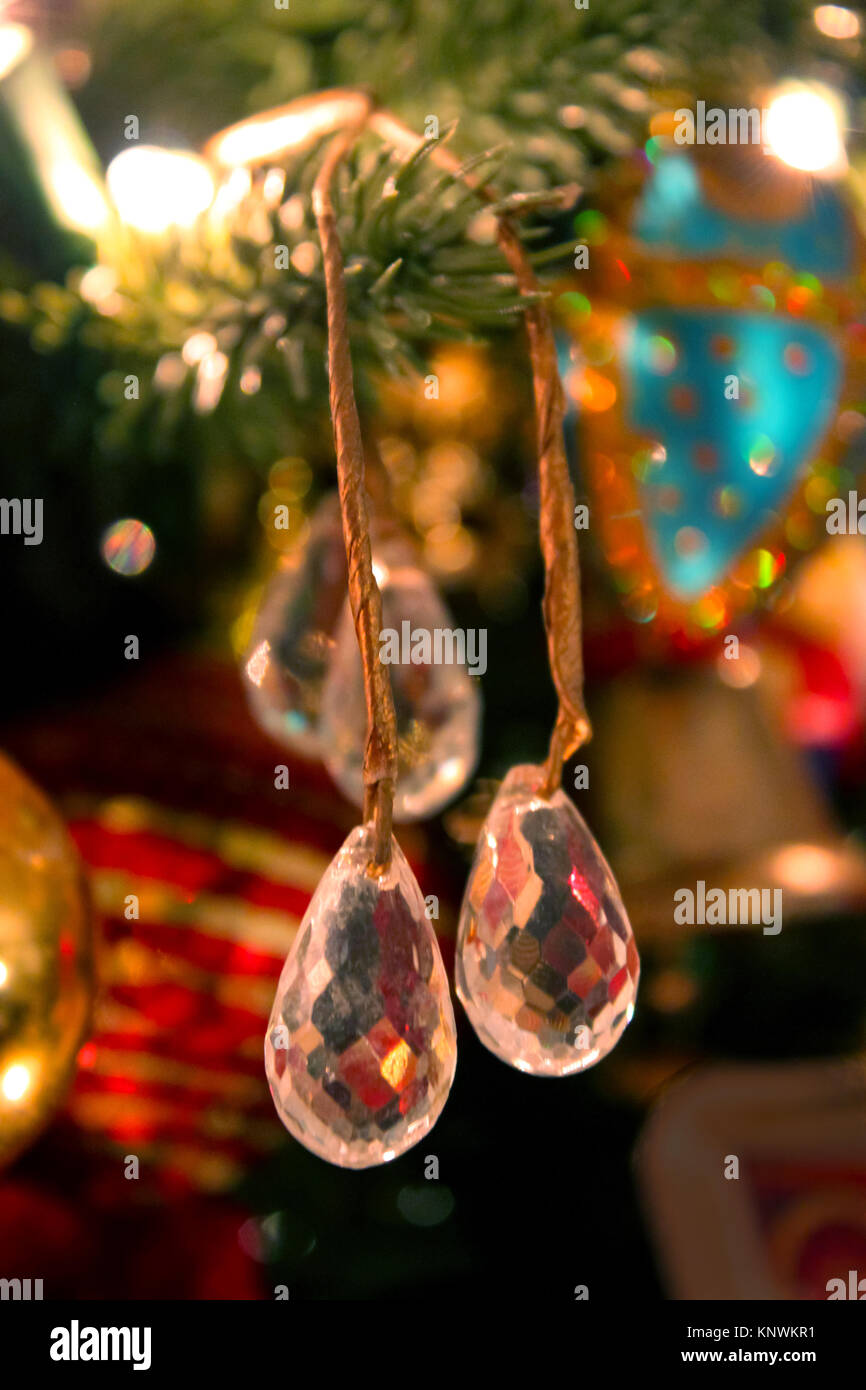 Gouttes cristal accrocher sur un arbre de Noël avec des ornements de flou en arrière-plan Banque D'Images