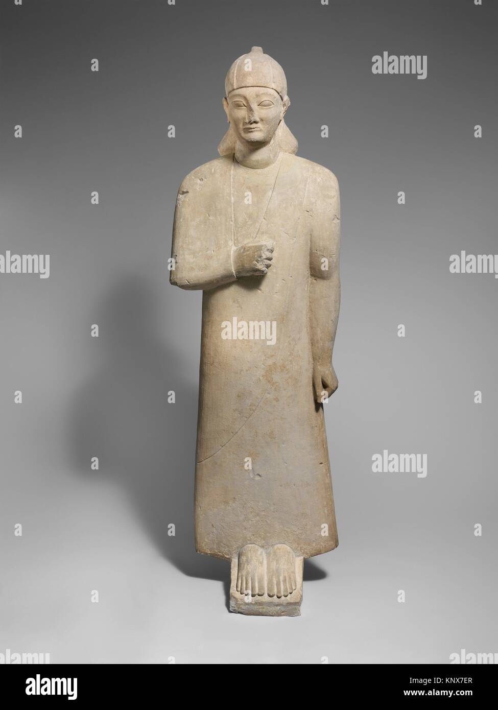 Votary calcaire d'un homme imberbe portant un long vêtement et d'un casque conique. Période : archaïque ; Date : ca. 550-525 av. J.-C. ; Culture ; Moyenne : chypriote : Banque D'Images