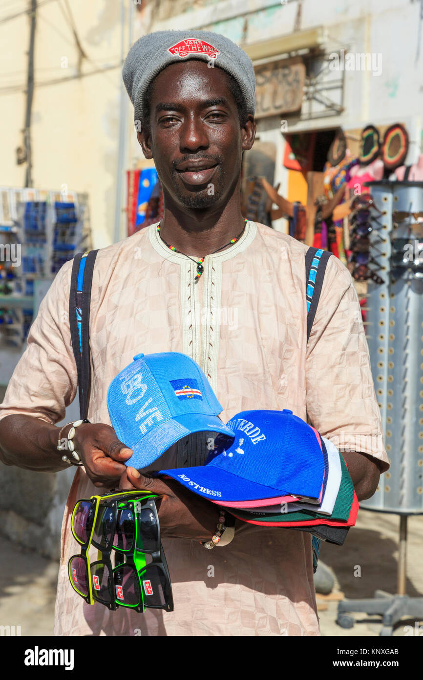 L'homme du Sénégal vente de chapeaux de base-ball avec le Cap Vert gaufré  logo et de fausses Ray Ban lunettes de soleil à la zone touristique de  Santa Maria Cape Verde Photo