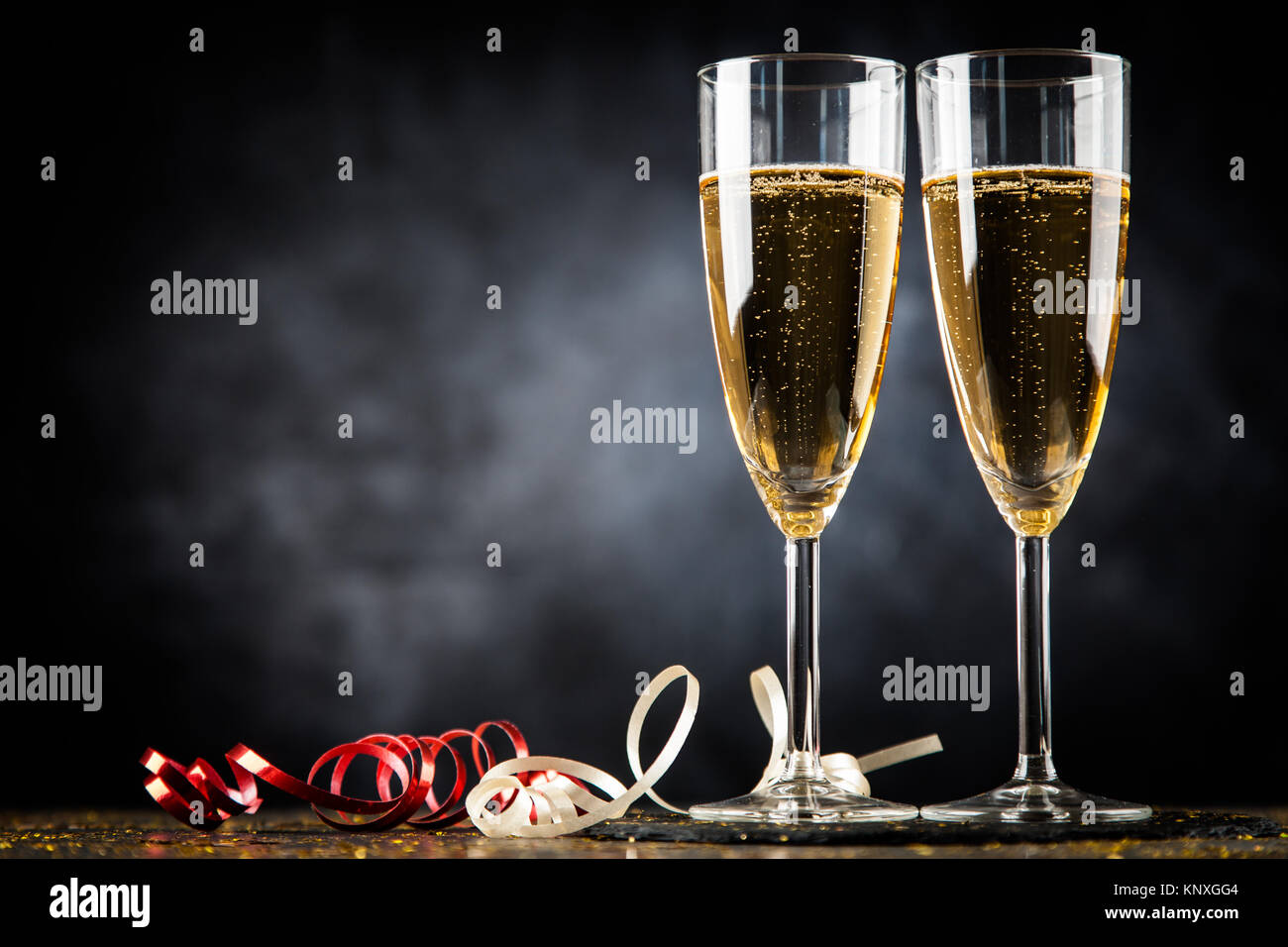 Deux verres de champagne dans la région de golden glitter, fond sombre Banque D'Images