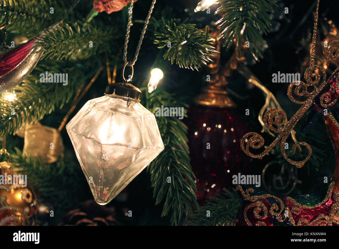 Ornement de forme diamant verre mercure suspendu à une branche sur une ancienne vintage de Noël avec d'autres ornements dans l'arrière-plan Banque D'Images
