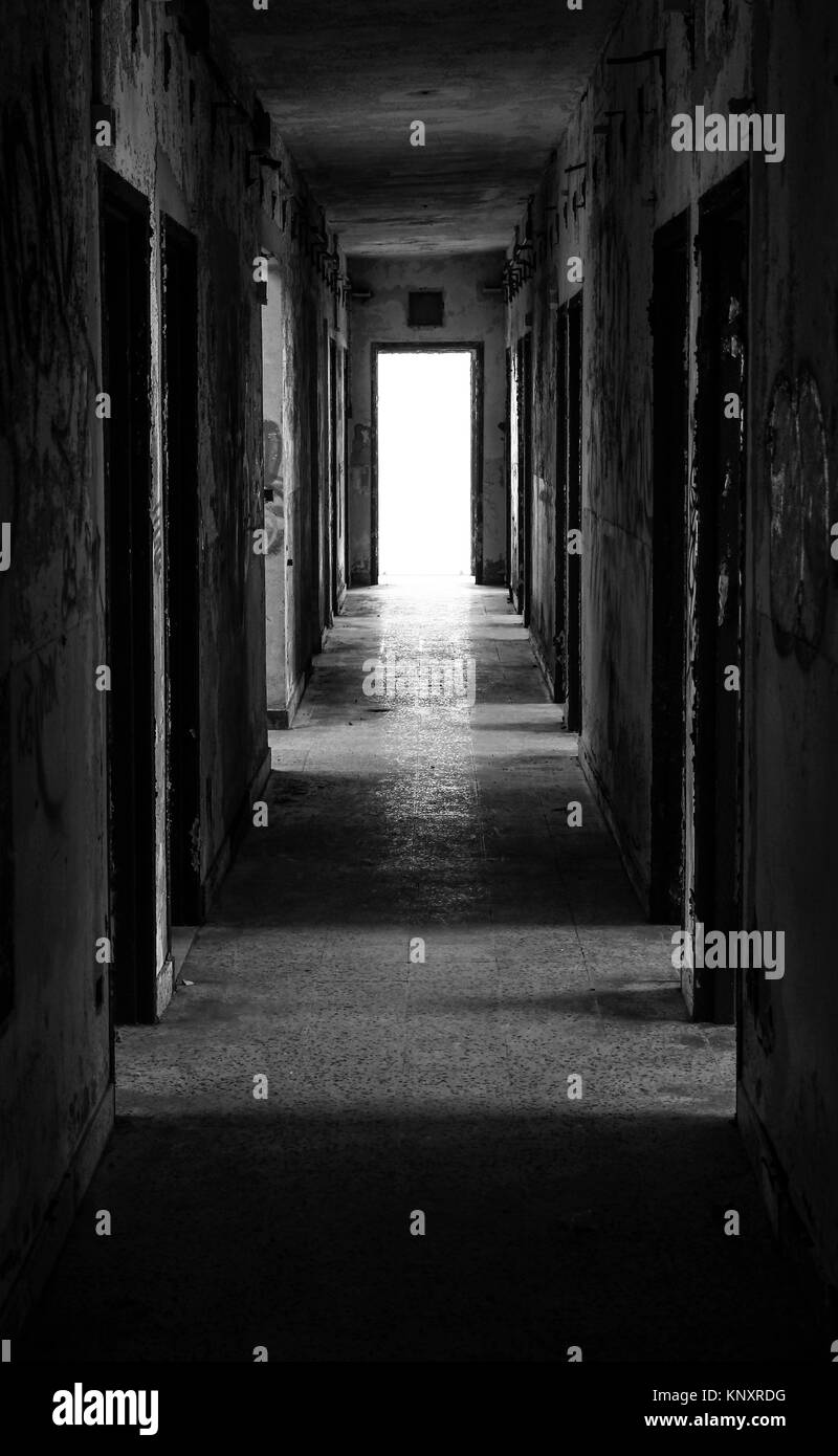 Couloir d'un vieux bâtiment abandonné et sombre en bas vous voyez un allumé sortie. Banque D'Images