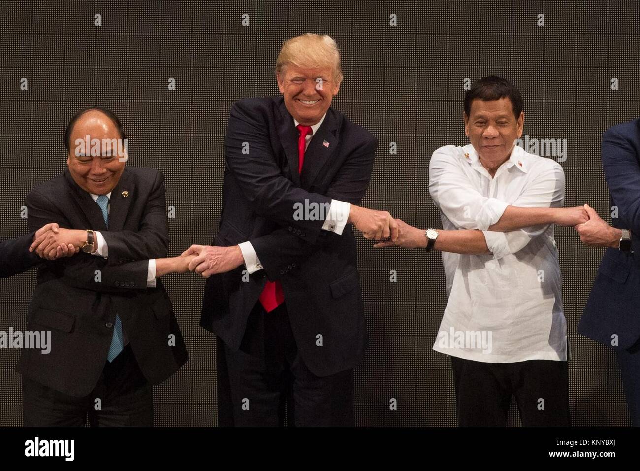 Le Président américain Donald Trump, centre, tient la main de la présidente philippine Rodrigo Duterte, droite, et Premier ministre vietnamien Nguyen Xuan Phuc, au cours de la photo de groupe des dirigeants pour la cérémonie d'ouverture du sommet de l'ASEAN au Philippine International Convention Center le 13 novembre 2017 à Pasay City, Manille, Philippines. Banque D'Images