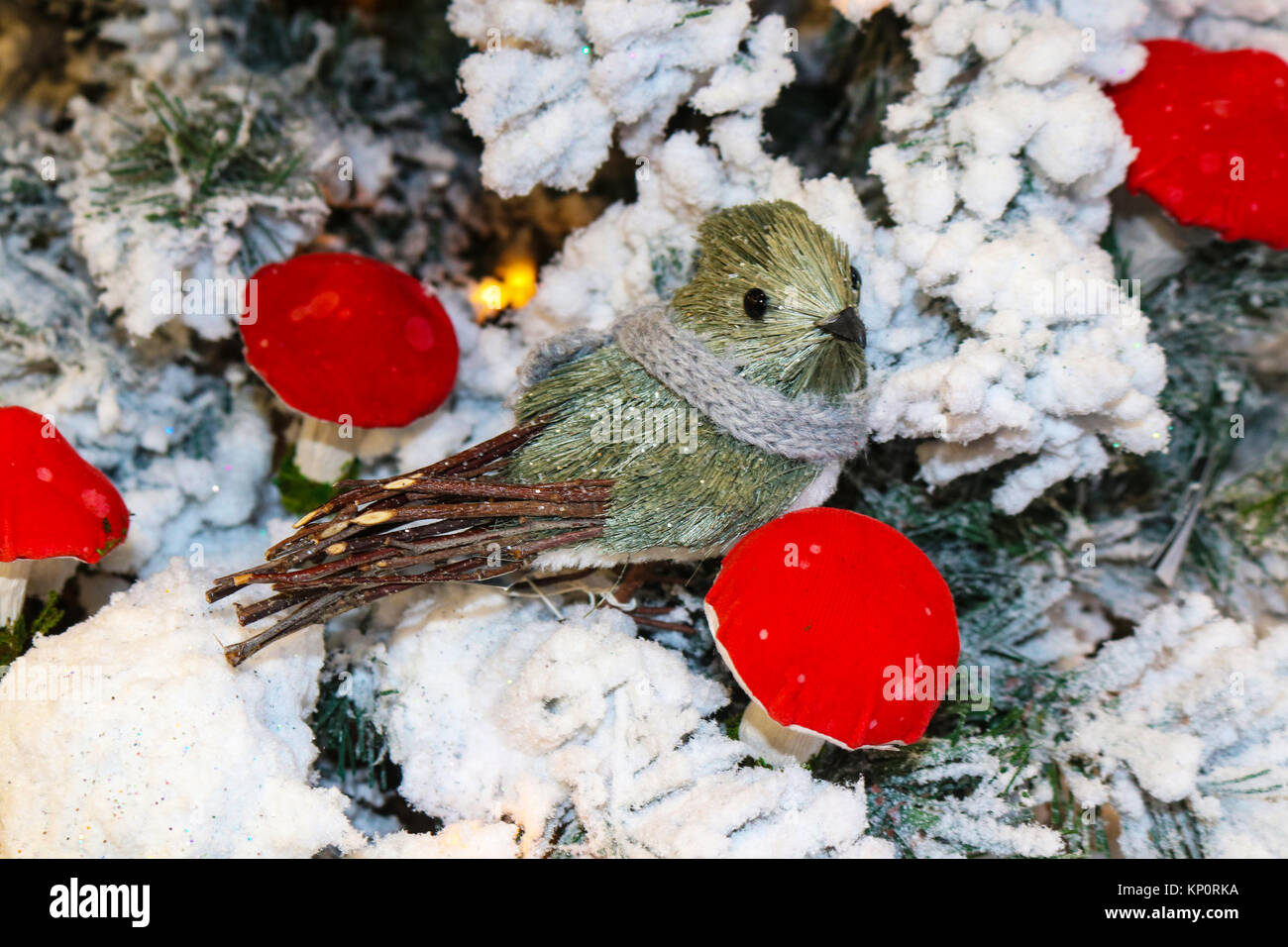 Scène Woodlands- brosse douce et stick oiseau avec écharpe en tricot sur arbre de Noël floqué avec champignons rouge vif Banque D'Images