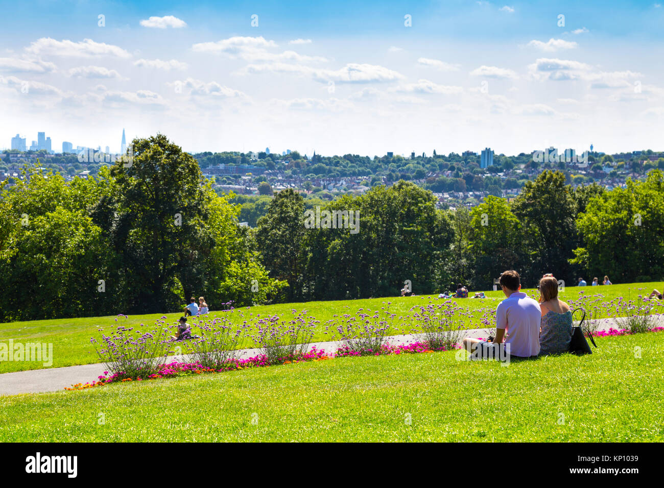 Couple sitting in Alexandra Palace Park à la recherche au niveau de la vue de la ville de Londres dans la distance, London, UK Banque D'Images